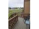 Balcony with views of a community green space, wooden railings, and outdoor seating at 11811 E Maplewood Ave, Englewood, CO 80111