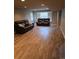 Finished basement living room with wood-look floors, leather couches, and natural light at 11811 E Maplewood Ave, Englewood, CO 80111