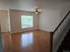 Spacious living room features hardwood floors, natural light, staircase, and a ceiling fan at 11811 E Maplewood Ave, Englewood, CO 80111