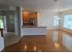 Open-concept living space with hardwood floors, a breakfast bar, and access to dining area at 11811 E Maplewood Ave, Englewood, CO 80111