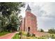 Low angle view of ornate brick building with arched entrance and well-manicured lawn and landscaping at 2442 S Saint Paul St, Denver, CO 80210