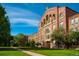 Classic brick building featuring arched windows and entrances, surrounded by green lawn and trees at 2442 S Saint Paul St, Denver, CO 80210