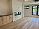 Living room showcasing hardwood floors, a modern fireplace, built-in cabinetry, and black frame windows at 2442 S Saint Paul St, Denver, CO 80210
