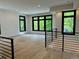 Open loft area with hardwood floors, black metal railing, and multiple black frame windows at 2442 S Saint Paul St, Denver, CO 80210