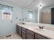 Bathroom with dual sinks, large mirror, and shower at 5795 S Pagosa Way, Centennial, CO 80015