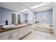 Bright bathroom with double sinks, soaking tub, and skylights at 5795 S Pagosa Way, Centennial, CO 80015