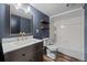 Bathroom features a vanity with gold faucet, floating shelves, and a tub with shower at 5795 S Pagosa Way, Centennial, CO 80015