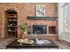 Elegant brick fireplace with mantel, built-in shelves, and a coffee table at 5795 S Pagosa Way, Centennial, CO 80015