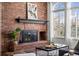 Classic fireplace with mantel, brick surround, and adjacent window with natural light at 5795 S Pagosa Way, Centennial, CO 80015