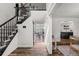Bright foyer featuring hardwood floors, a staircase with black banister, and views of the living spaces at 5795 S Pagosa Way, Centennial, CO 80015