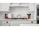Close-up of a kitchen cooktop with white cabinetry and quartz countertops at 5795 S Pagosa Way, Centennial, CO 80015