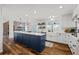 Bright kitchen with an island, white cabinetry, stainless steel appliances, and hardwood floors at 5795 S Pagosa Way, Centennial, CO 80015