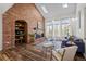 Cozy living room with vaulted ceiling, brick fireplace with display, large windows, and hardwood floors at 5795 S Pagosa Way, Centennial, CO 80015