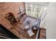 Open living room with exposed brick fireplace, hardwood floors, and large windows offering lots of natural light at 5795 S Pagosa Way, Centennial, CO 80015