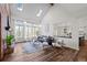 Bright living room with a vaulted ceiling, skylights, brick fireplace, hardwood floors, and access to kitchen at 5795 S Pagosa Way, Centennial, CO 80015