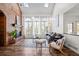 Cozy living room with vaulted ceiling, brick fireplace, large windows, and hardwood floors at 5795 S Pagosa Way, Centennial, CO 80015