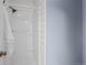 All-white shower with white tile surround at 5795 S Pagosa Way, Centennial, CO 80015