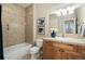 Bright bathroom with a bathtub, tile surround, modern vanity, and stylish fixtures offers a relaxing experience at 3212 Pierce St, Wheat Ridge, CO 80033