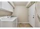 Bright laundry room features cabinetry, tile floor, and a washer and dryer at 3212 Pierce St, Wheat Ridge, CO 80033