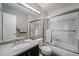 Bathroom featuring sliding glass shower doors, a large mirror, and neutral tiling at 1050 S Monaco Pkwy # 35, Denver, CO 80224