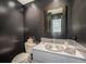 Modern powder room with dark walls, vessel sink, unique mirror, and sleek fixtures at 1050 S Monaco Pkwy # 35, Denver, CO 80224