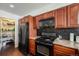 Kitchen features wooden cabinets, granite countertops, black appliances, tile backsplash, and walk-in pantry at 1050 S Monaco Pkwy # 35, Denver, CO 80224
