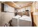 Functional laundry room includes two white washing machines and a shelving unit for storage at 1050 S Monaco Pkwy # 35, Denver, CO 80224