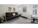 Living room featuring a black futon, desk, artwork, and large window at 1050 S Monaco Pkwy # 35, Denver, CO 80224