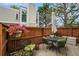 Serene patio area with outdoor seating, vibrant flowers, and a wooden fence at 1050 S Monaco Pkwy # 35, Denver, CO 80224