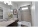 Well-lit bathroom featuring granite countertops, a modern shower with gray tile, and new wood-look flooring at 46550 Avery Ln, Bennett, CO 80102