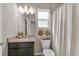 Bright bathroom featuring a granite countertop, modern vanity, and a shower with a neutral-colored shower curtain at 46550 Avery Ln, Bennett, CO 80102