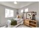 Inviting bedroom with natural light from two windows and stylish décor, including a wooden side table at 46550 Avery Ln, Bennett, CO 80102