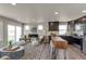 Bright living room with large windows, a fireplace, and an island bar with seating at 46550 Avery Ln, Bennett, CO 80102