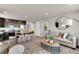 Living space features an island with barstool seating, opening into a living area with a couch and decor at 46550 Avery Ln, Bennett, CO 80102