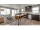 Open-concept living space with a large window, an electric fireplace, and wood kitchen island seating at 46550 Avery Ln, Bennett, CO 80102