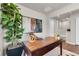 Home office with a large wooden desk, decorative items, and a green plant at 46550 Avery Ln, Bennett, CO 80102