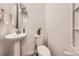 Half bath features a pedestal sink, toilet, and simple decor at 2967 S Quaker St, Morrison, CO 80465