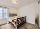 This bedroom features a dark-stained wooden bed frame, stylish dark wood flooring and plenty of natural light at 2967 S Quaker St, Morrison, CO 80465