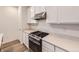 Close up on the stainless steel oven, stove, and hood with white cabinets and counters at 2967 S Quaker St, Morrison, CO 80465