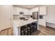Bright kitchen featuring an island with stools, stainless steel appliances, and white cabinetry at 2967 S Quaker St, Morrison, CO 80465