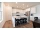 Modern kitchen features white cabinetry, stainless steel appliances, and a spacious island with seating at 2967 S Quaker St, Morrison, CO 80465