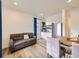 Bright living room with hardwood floors, couch, dining table, and stainless steel refrigerator at 2967 S Quaker St, Morrison, CO 80465