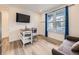 Open floor plan with hardwood floors, small table with stools, and television at 2967 S Quaker St, Morrison, CO 80465