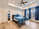 Bright main bedroom with a tray ceiling, ceiling fan, and plenty of natural light from the large windows at 2967 S Quaker St, Morrison, CO 80465