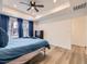 This primary bedroom boasts hardwood floors, a tray ceiling, and calming blue accents throughout the space at 2967 S Quaker St, Morrison, CO 80465
