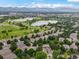 Expansive aerial view shows the neighborhood's proximity to a lush green golf course and serene lakes at 6700 W Dorado Dr # 47, Littleton, CO 80123