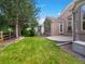 Backyard view of home, patio, fenced yard, grass, and surrounding trees at 6700 W Dorado Dr # 47, Littleton, CO 80123