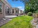 Backyard view of home, patio, fenced yard, grass, and surrounding trees at 6700 W Dorado Dr # 47, Littleton, CO 80123