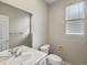 Neutral bathroom with a large mirror, modern sink, toilet, and window, creating a serene and functional space at 6700 W Dorado Dr # 47, Littleton, CO 80123
