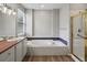Bright bathroom with a soaking tub, shower with a glass door, modern fixtures, and natural light from the window at 6700 W Dorado Dr # 47, Littleton, CO 80123